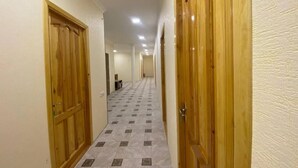 A hallway with wooden doors and tiled flooring.
