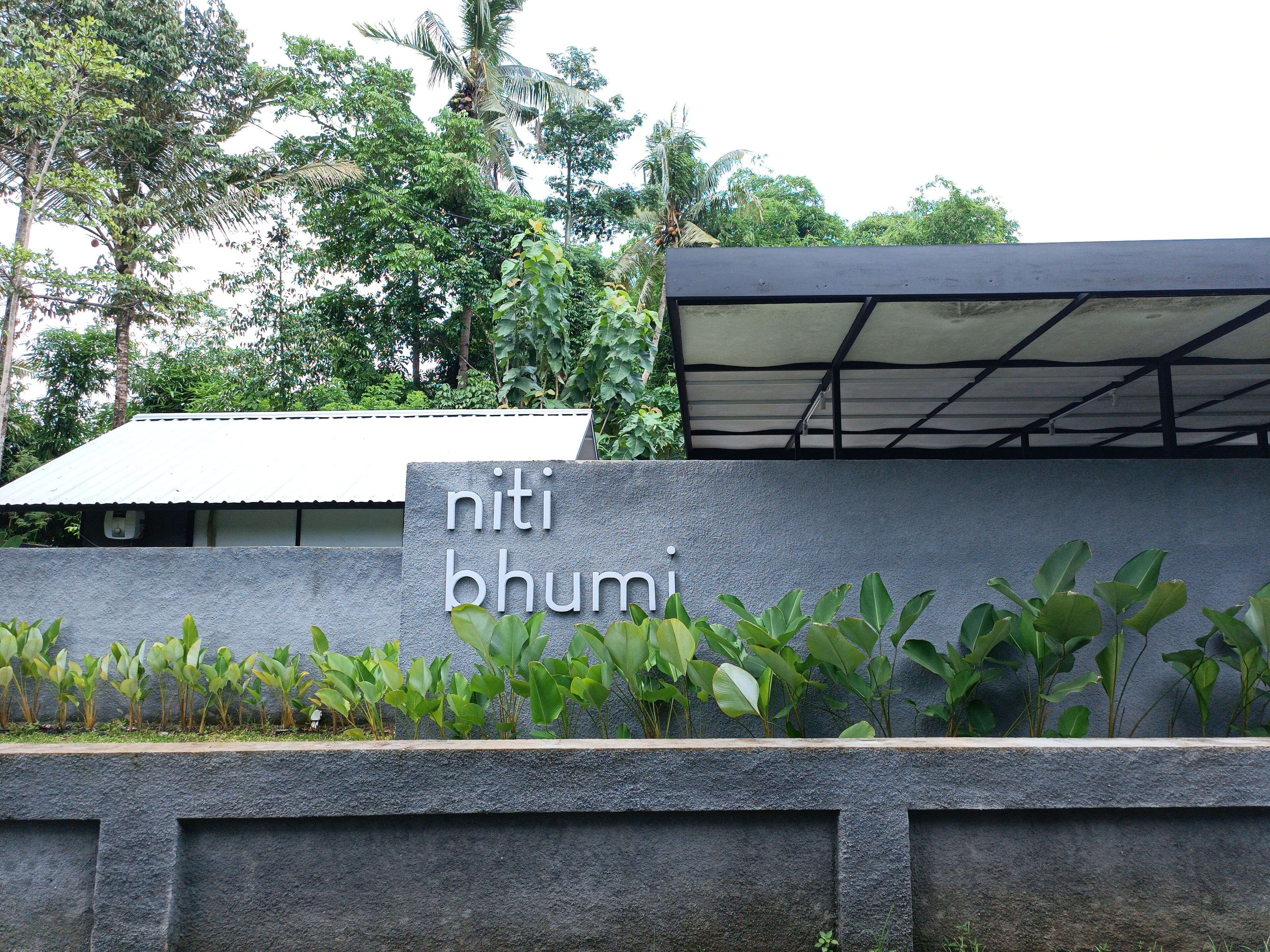 A stone wall with the inscription "niti bhumi" and a covered structure above it.