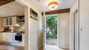 A kitchen with white cabinets, a built-in oven, and a wooden ceiling.