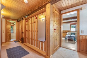 Ein Holzinterieur mit einer Tür, einer Fußmatte und einem Tisch mit Tischdecke.