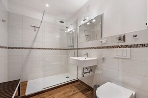 Une salle de bain moderne équipée d’une douche, d’un lavabo et de toilettes.