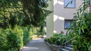 A paved pathway leading to a building with a staircase and a railing. - Apartment 'Zwergenbau' with Shared Garden, Balcony, and Wi-Fi (Badenweiler)
