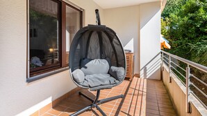 A balcony with a swing chair, a window, and a railing. - Apartment 'Zwergenbau' with Shared Garden, Balcony, and Wi-Fi (Badenweiler)