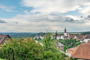 Une ville avec des maisons traditionnelles, une église et une colline en arrière-plan.