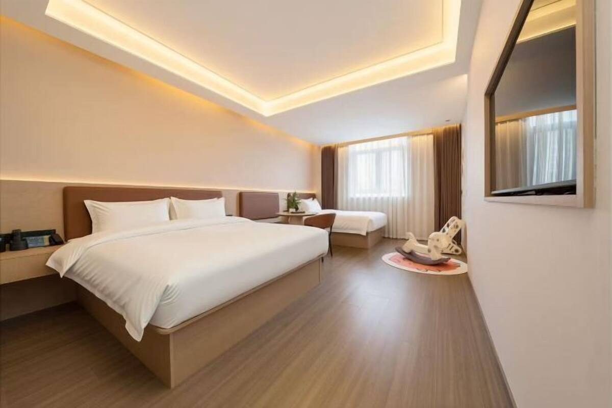 A modern hotel room with a large bed, bedside tables, a desk, and a chair.