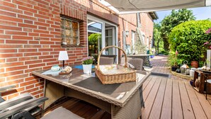 A patio area with a wicker table, a basket, and a lamp.