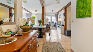A spacious kitchen with modern appliances, a dining area with patterned chairs, and a large mirror reflecting the room.