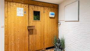 Eine Holztür mit Fenster, eine kleine Buddha-Statue und eine weiße, strukturierte Wand.
