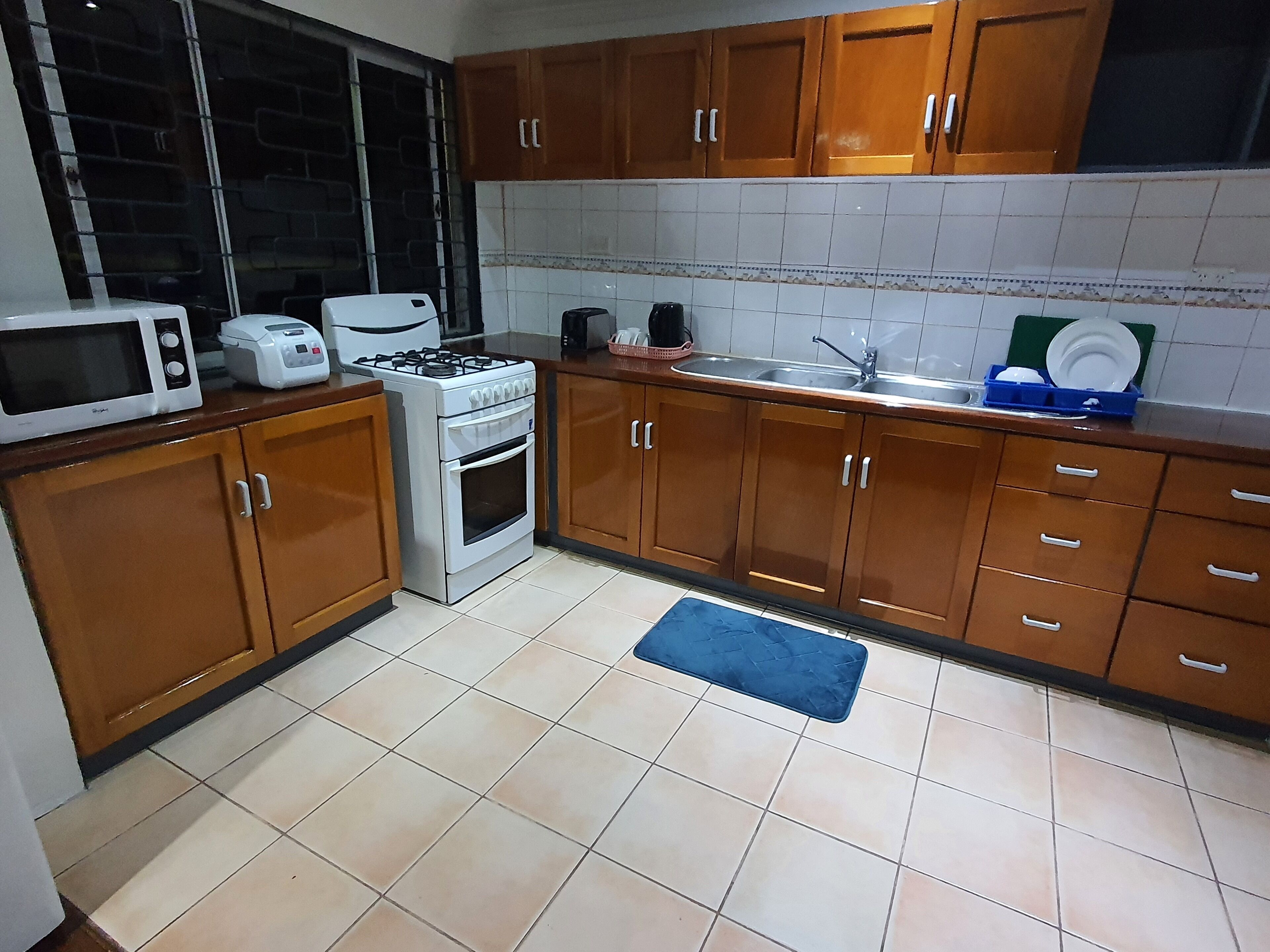 Una cocina con armarios de madera, un microondas, una estufa y un lavabo.