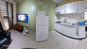 A compact living space with a kitchen, a dining area, and a bedroom. - Axis Apartments (Suva)
