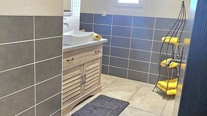 A bathroom with a sink, mirror, and towel rack.