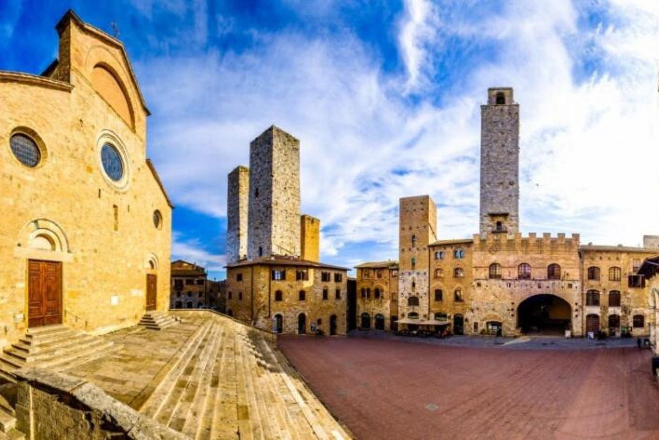 A historic building with a central tower, a courtyard, and a large arched entrance.