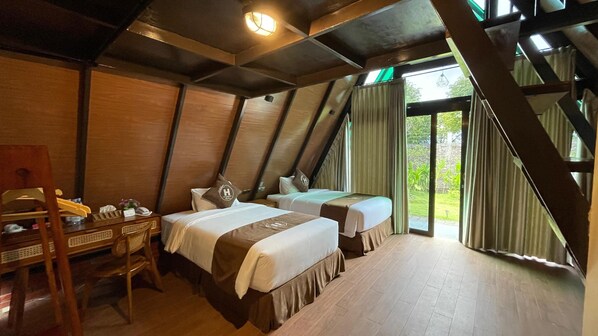 A room with two beds, wooden furniture, and a view of greenery outside. - Harmony Magelang Syariah (Mertoyudan)