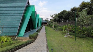 Un chemin menant à un bâtiment doté d’un toit végétalisé et d’une architecture moderne.