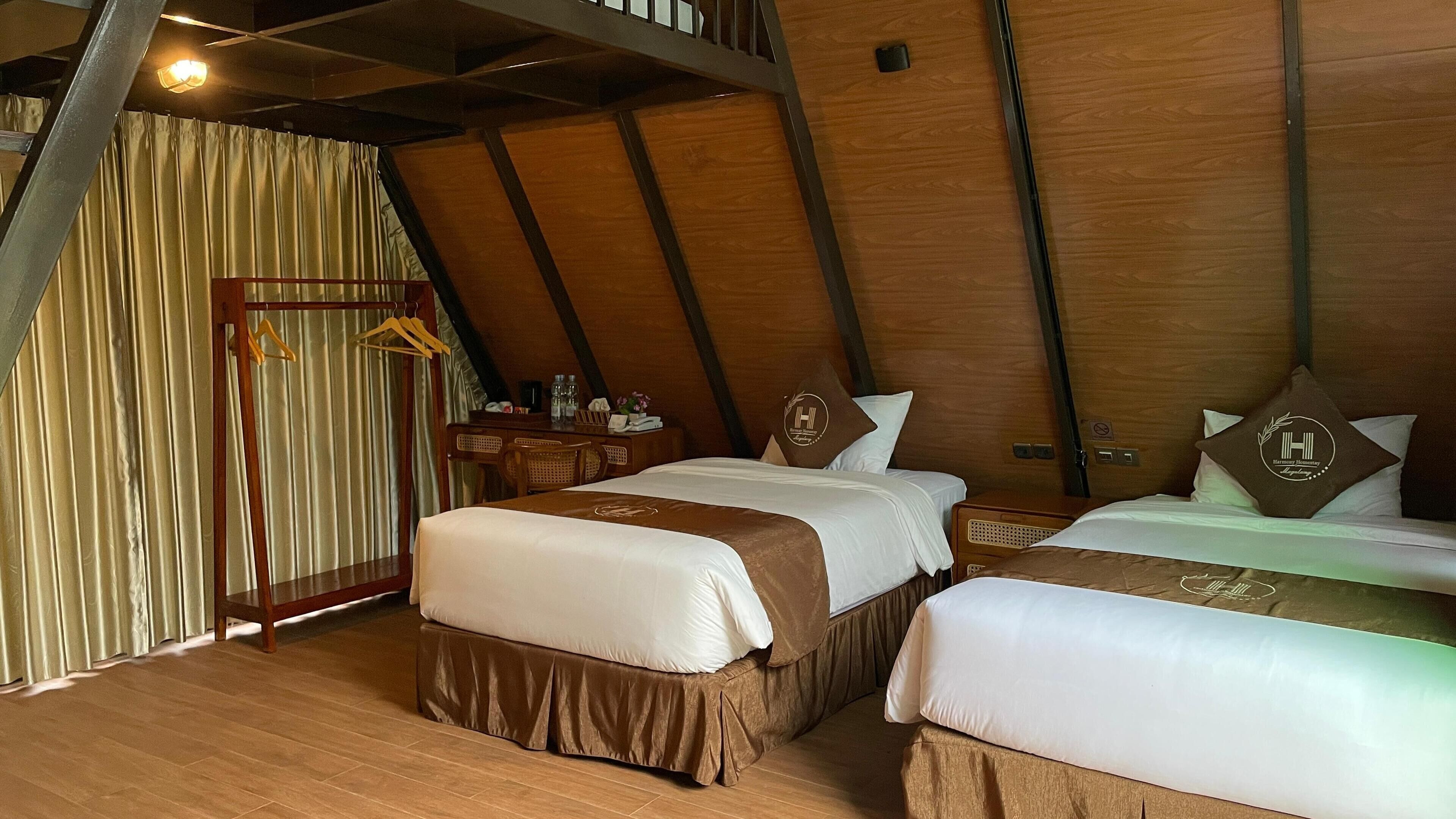Een gezellige kamer met houten vloer, twee bedden, een hangstoel en een bureau met lamp.