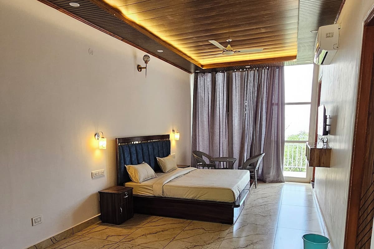 Une chambre à coucher moderne, équipée d’un lit, de tables de chevet, d’un ventilateur de plafond et offrant une vue sur l’extérieur.