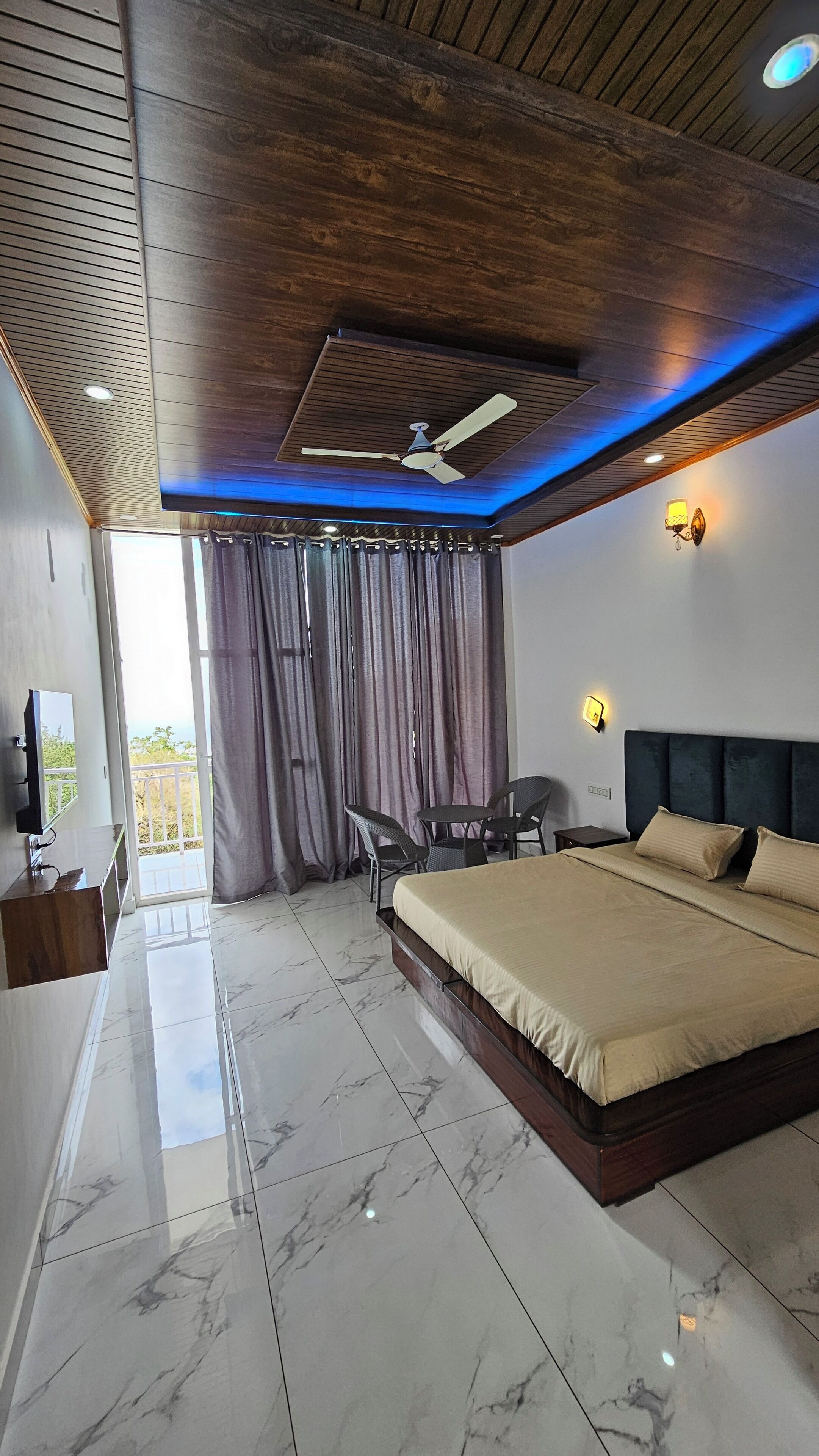 Un dormitorio moderno con una cama grande, un ventilador de techo y vistas al exterior.