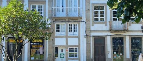 A building with multiple floors, a balcony on the second floor, and a sign for 'Central' on the ground floor.