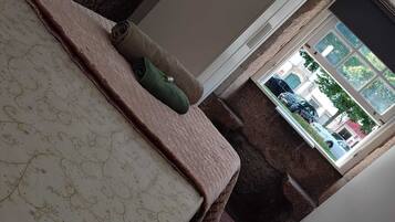 Un dormitorio con cama, ventana y vistas al exterior.
