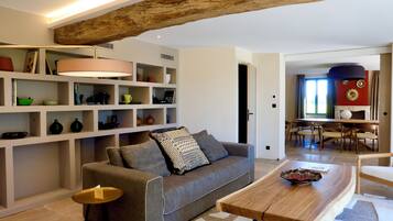 Una sala de estar moderna con un sofá gris, una mesa de centro de madera y una estantería llena de objetos decorativos.
