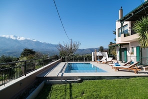 Ein Pool mit Liegestühlen und Blick auf Berge.