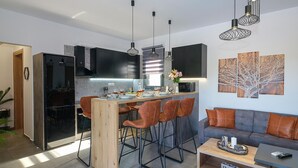 A modern kitchen with a central island, bar stools, and pendant lighting. - Villa Eleonas With Private Swimming Pool (Rethymno)