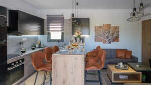 Une cuisine moderne dotée d’un îlot central, d’un coin repas et d’un espace détente.