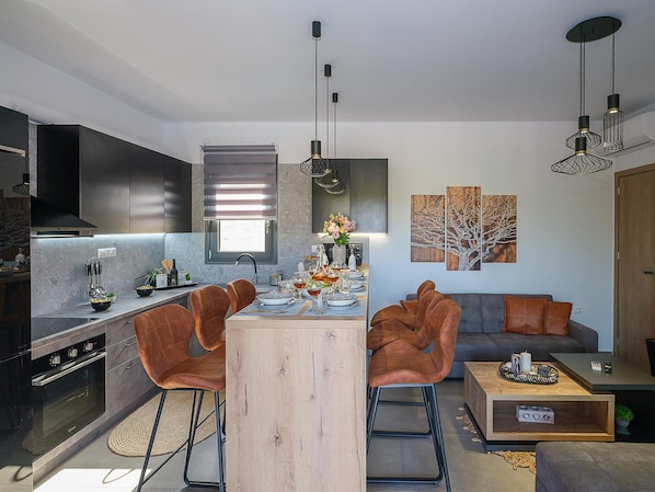 A modern kitchen with a central island, dining area, and seating space. - Villa Eleonas With Private Swimming Pool (Rethymno)