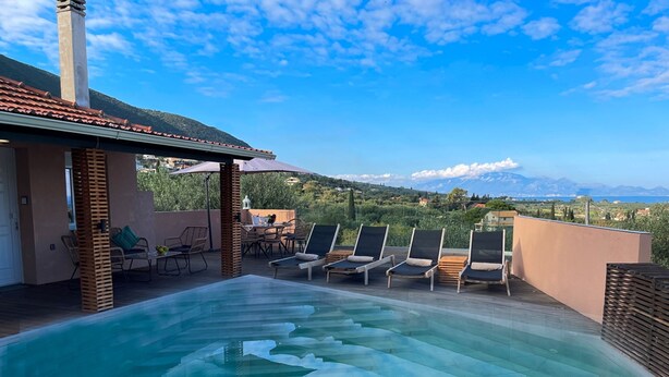 A rooftop infinity pool with lounge chairs and a table, overlooking a mountainous landscape. - Villa De La Vita Alykes (Zakynthos)