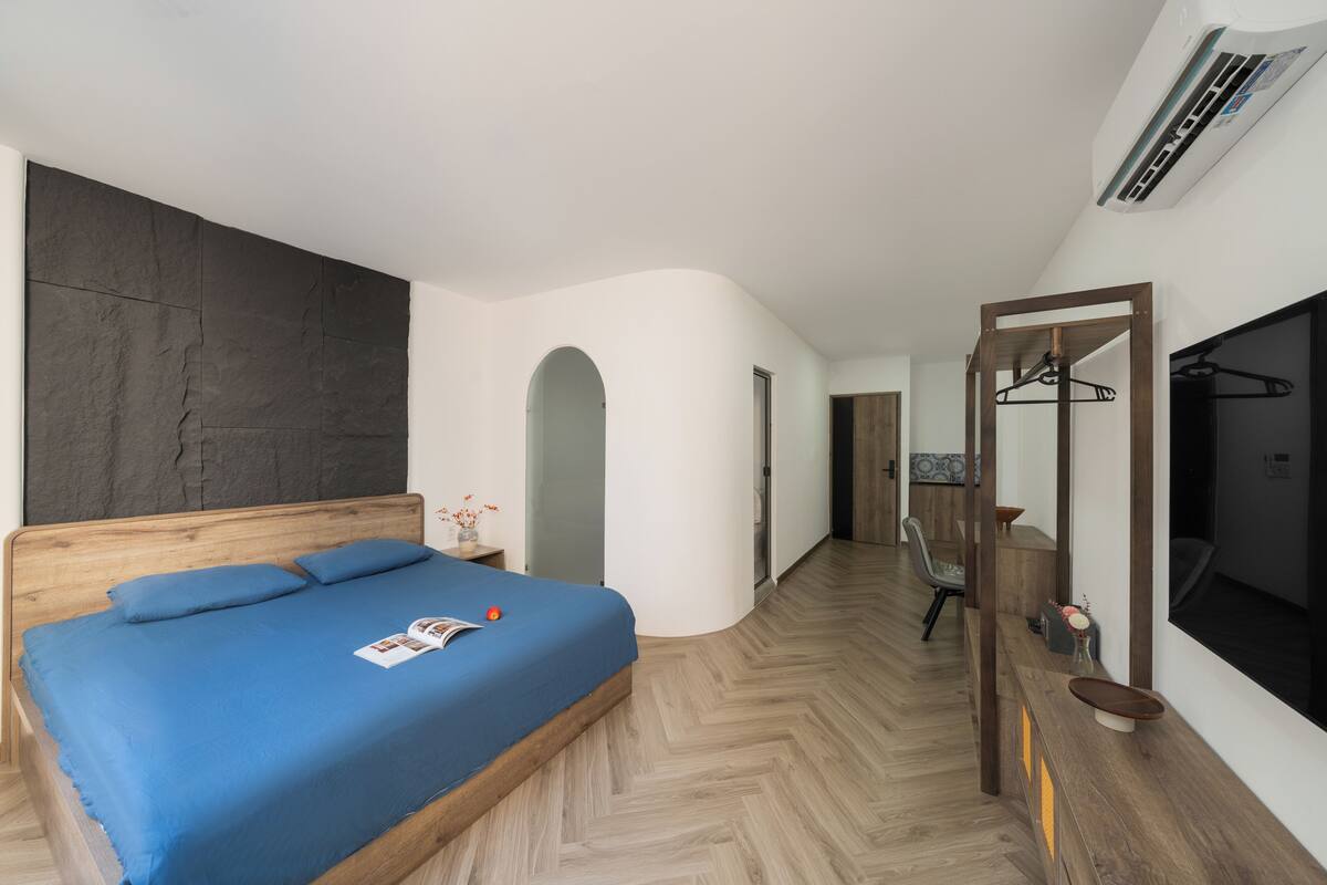 Ein Schlafzimmer mit einem Holzbett, einem großen Spiegel und einem Fernseher.