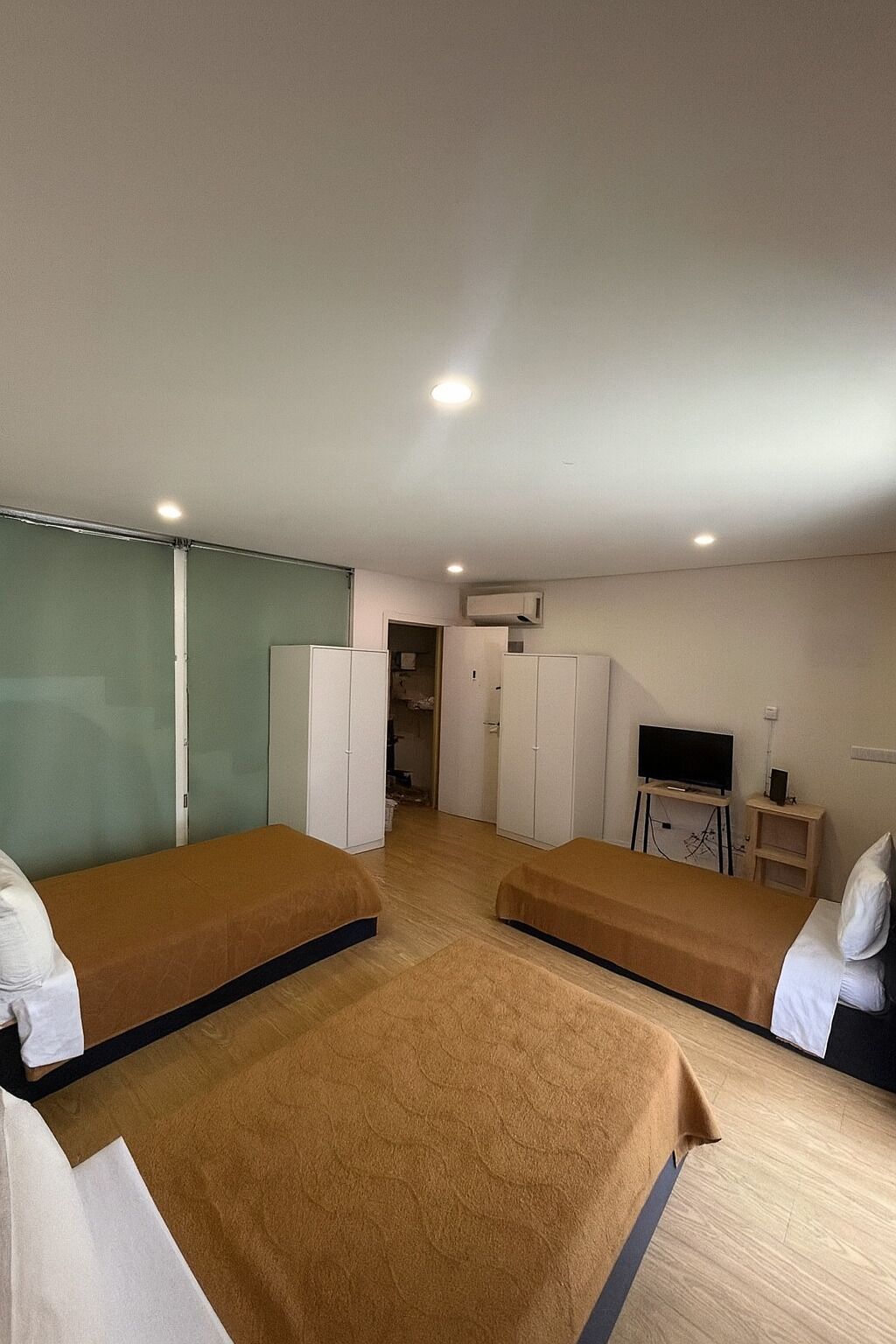 Une chambre d’hôtel avec deux lits, une télévision, un bureau et une armoire.