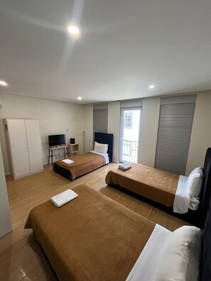 A hotel room with two beds, a desk, a TV, and a wardrobe. - Casa Augusta 4 (Braga)