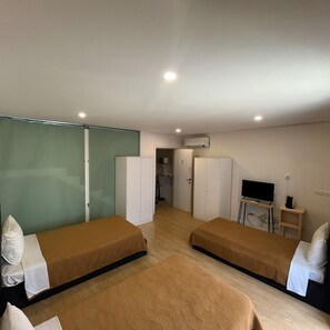 A room with two beds, a television, and a wardrobe. - Casa Augusta 4 (Braga)