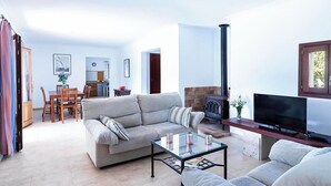 Una sala de estar con sofá, mesa de centro, televisor y chimenea.