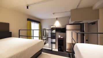 Ein Hotelzimmer mit zwei Betten, einem Schreibtisch, einem Fernseher und einem Kleiderschrank.