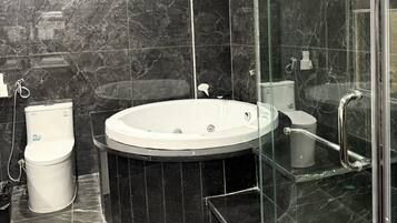 A modern bathroom with a freestanding bathtub, a glass-enclosed shower, and a toilet.