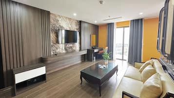 Una sala de estar moderna con una televisión de pantalla plana, un sofá, una mesa de centro y una chimenea.