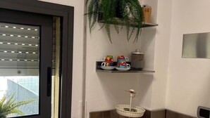 Una cocina moderna con ventanal, planta y estación de café.