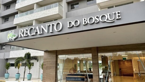 Entrada de hotel con un cartel que dice "Recanto do Bosque".