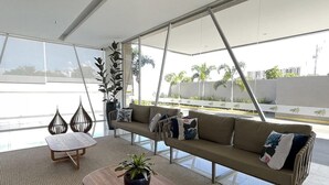 Una sala de estar moderna con un sofá, una mesa de centro y plantas en macetas.