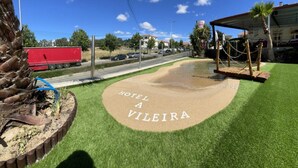 L’entrée d’un hôtel, avec une enseigne indiquant « HOTEL A VILEIRA », se trouve sur une pelouse.