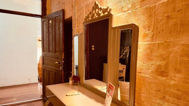A room with a wooden desk, a mirror, and a door. - Fazilet Hanım Konağı (Gaziantep)