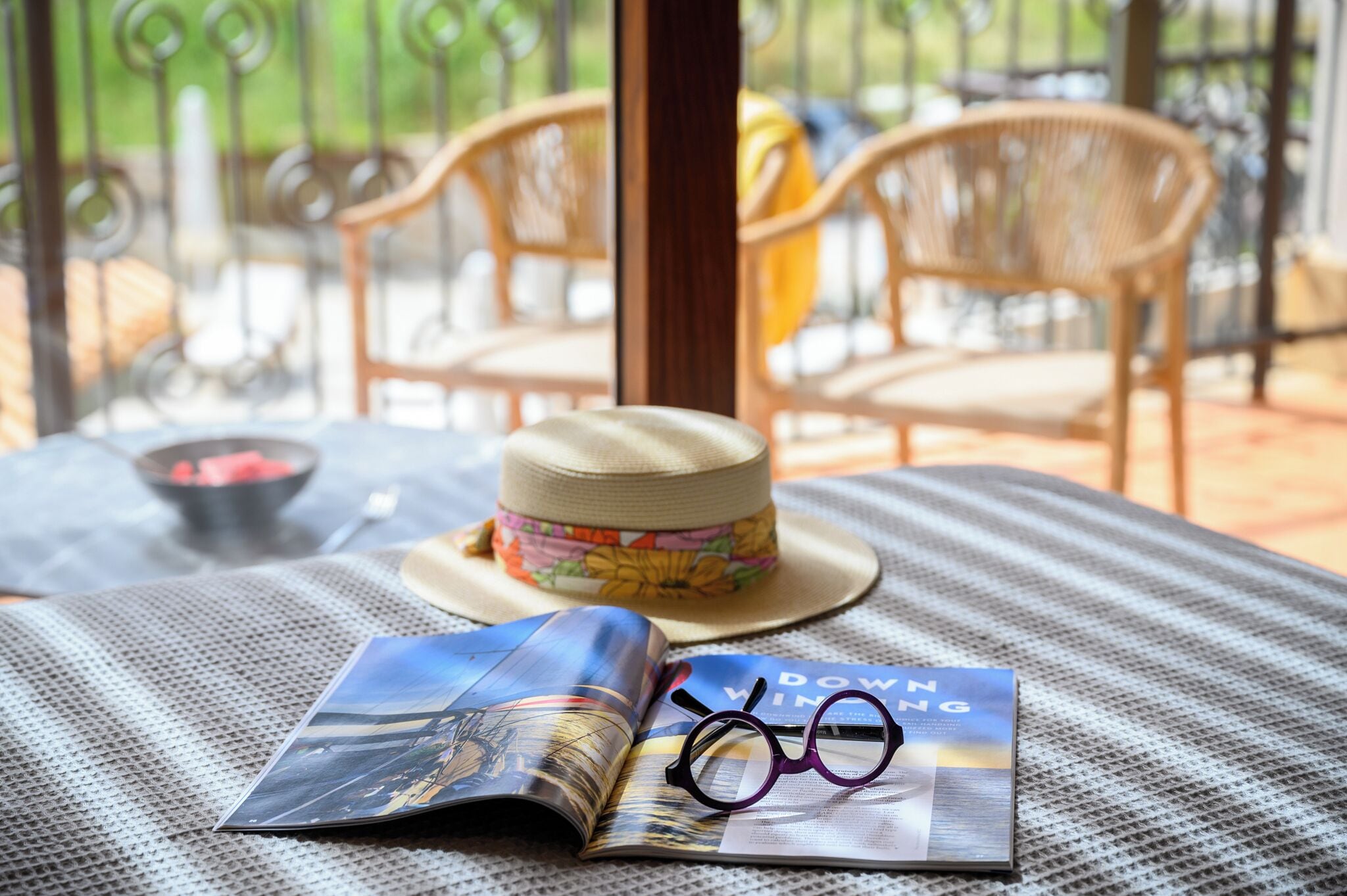 A table with a hat, glasses, and a magazine.