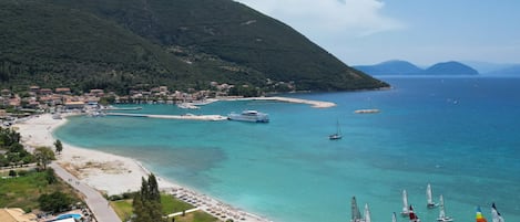 Un pueblo costero con playa, barcos y veleros.
