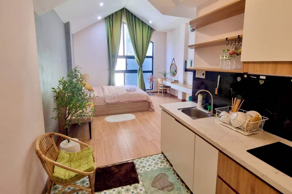 Un espace de vie compact comprenant une kitchenette, un coin repas et une chambre.