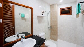 A bathroom with two sinks, a toilet, a shower, and a mirror. - Mango Home & Apartment (Da Nang)