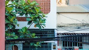 A building with a white facade, a window with a geometric pattern, and a visible number "29" on the gate. - Mango Home & Apartment (Da Nang)