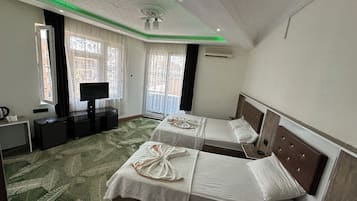Habitación cuádruple Deluxe | Sábanas de algodón egipcio, ropa de cama de alta calidad y minibar