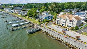 A riverside hotel with a dock, a parking area, and a road leading to the hotel. - Unbelievable beach views for 6 (North Beach)