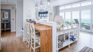 A modern kitchen with a wooden island, white cabinetry, and pendant lighting. - Shearwater 30 - 2 Bedroom Lodge - Summerhill (Narberth)